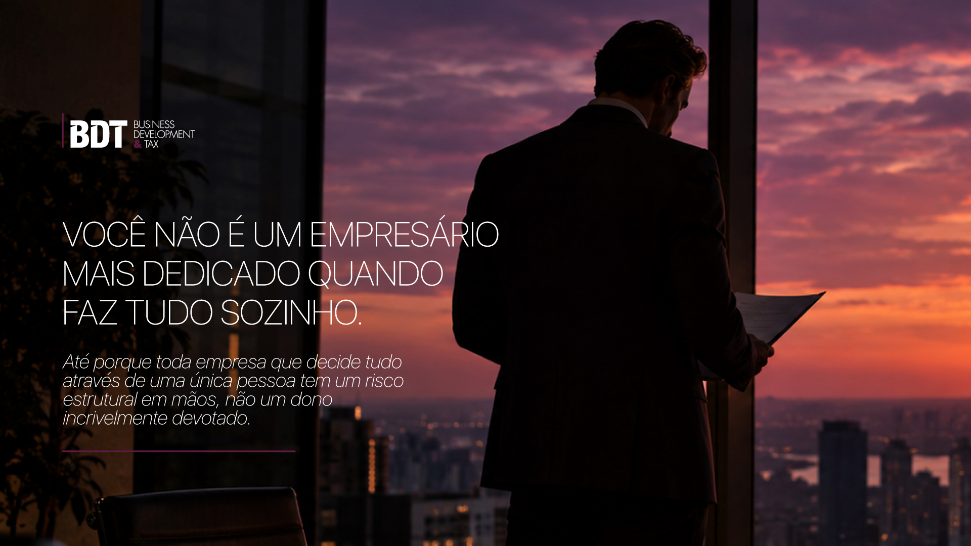 Empresário de terno, de costas, lendo documentos diante da janela ao entardecer